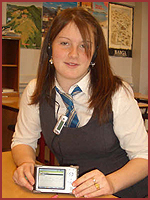 Image of a teenaged girl sitting in a classroom holding an mp3 player 